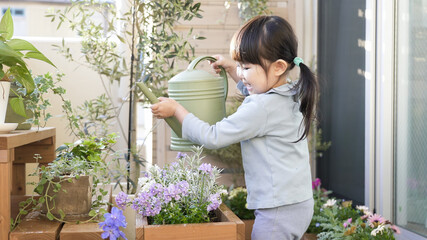 ベランダガーデニングで花に水やりする子供
