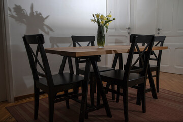 Bouquet of fresh narcissus in vase on a wooden table