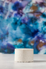 Empty concrete podium for the presentation of cosmetic products on a blue background. Empty. Copy space.