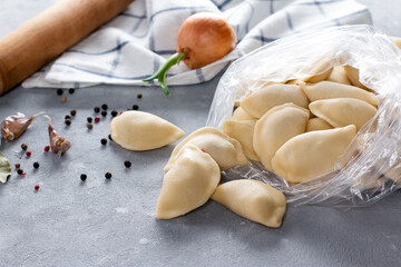 Dumplings. Frozen dumplings in the bag on grey table. Traditional food. Top view. Copy space