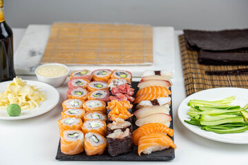 Sushi rolls prepared by professional asian chef with traditional Japanese ingredients. Salmon fish, rice, vegetables, sesame seeds.  Sushi cooking and seafood making concept