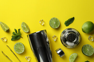 Cocktail shaker and ingredients for mojito on yellow background