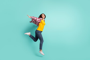 Fototapeta na wymiar Full length body size view of attractive cheerful carefree girl jumping having fun walking isolated over bright teal turquoise color background