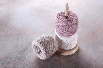 Skeins of pastel-colored yarn on wooden stand.Delicate yarn color. Natural wool yarn.Hobby...