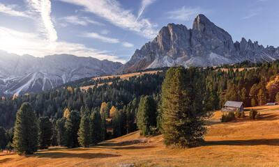 Amazing sunny mountain landscape. Stunning nature scenery with mountain valley, forest and majestic rocky mount on background, Dolomite alps. Italy. Popular travel and hiking destination.