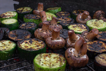 Grilled vegetables. Grill on a picnic. Food on an open fire. Zucchini, eggplant and mushrooms. Vegetarian dish. Healthy eating. Fresh vegetables on the wire rack. Delicious and healthy food.