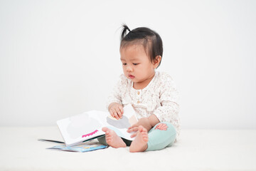 Portrait of asian baby girl, reading a Storybook.