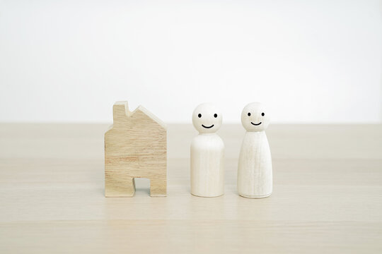 Happy Family And New Home Concept. Family Wooden Peg Doll On Wood Table.