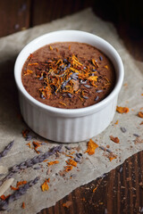 Chocolate vegan dessert - aquafaba mousse - egg free, non-dairy cocoa pudding or souffle decorated with lavender on dark moody background, closeup, vegan and vegetarian food concept