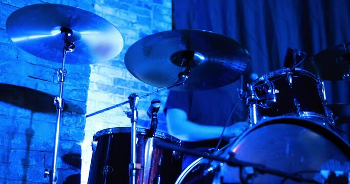 Unrecognizable drummer playing on a stage at concert