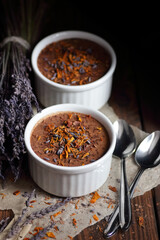Chocolate vegan dessert - aquafaba mousse - egg free, non-dairy cocoa pudding or souffle decorated with lavender on dark moody background, closeup, vegan and vegetarian food concept