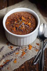 Chocolate vegan dessert - aquafaba mousse - egg free, non-dairy cocoa pudding or souffle decorated with lavender and saffron on dark moody background, closeup, vegan and vegetarian food concept