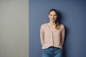 Smiling slender young woman in jeans in a studio portrait