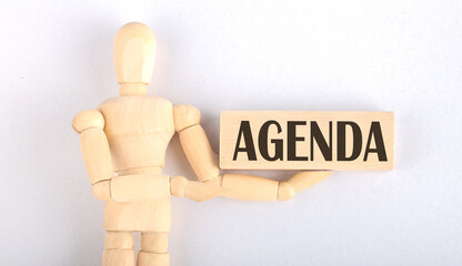 Wooden man shows with a hand to block with text AGENDA