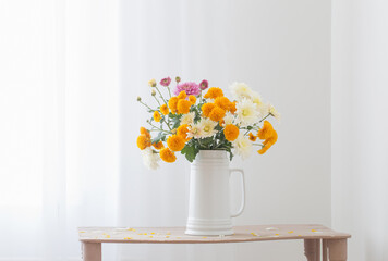 chrysanthemum flowers in white jug in white interior