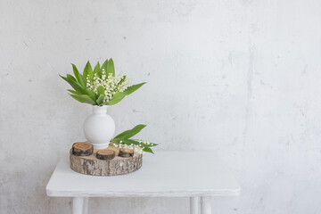 lily of the valley in vase on background old white wall © Maya Kruchancova