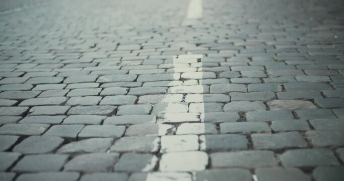 Close up view of pavin slabs with road marking under the feet of operator