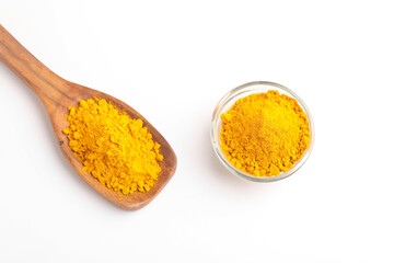 Turmeric powder in wooden spoon and glass bowl on white background.