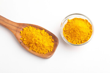 Turmeric powder in wooden spoon and glass bowl on white background.