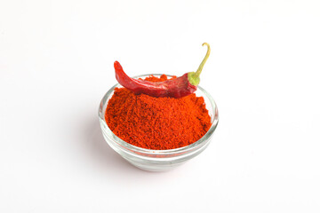 Dried red chilli and powder in glass bowl on white background.