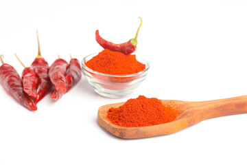 Dried red chilli and powder in glass bowl on white background.
