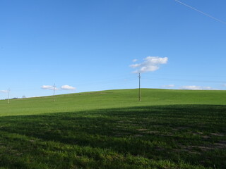 Fototapeta na wymiar power lines on a field with beautiful sky background