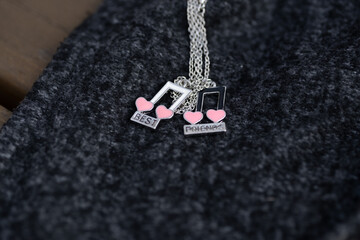 Pendant best friends two colors musical notes necklace shoot outside in a sunny day closeup....