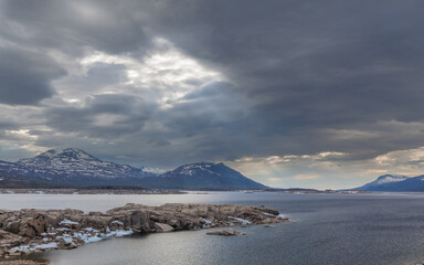 Landscape with the lake Akkajaure and mountains under a dark, overcast sky, Sweden. 