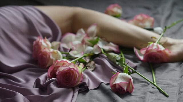 Romantic picture of preparing a date - tender legs and rose flowers
