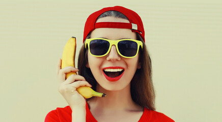 Portrait of funny woman calling on a banana phone on a background