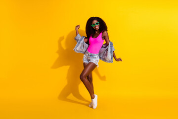 Fototapeta na wymiar Full length photo of afro american stunning girl dance wear sunglass isolated on yellow color background