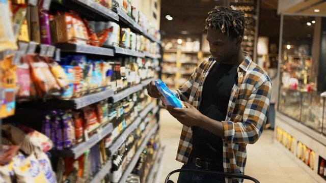 African american guy looking for products in the grocery store
