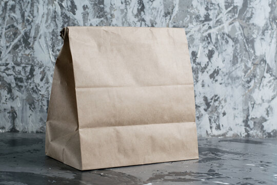 Craft Takeaway Food Bag On Gray Background With Copy Space. The Concept Of Delivery, Food To Go, Development Of The Restaurant Business Under Quarantine Covid 19