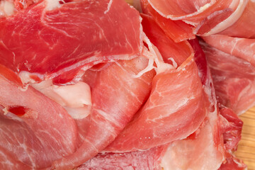 Background of jamon slices close-up, top view