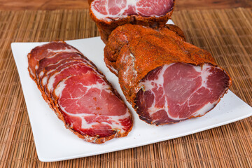 Pieces and slices of dry-cured pork neck close-up
