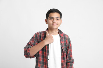 Young indian boy in a casual outfit and showing expression on white background.