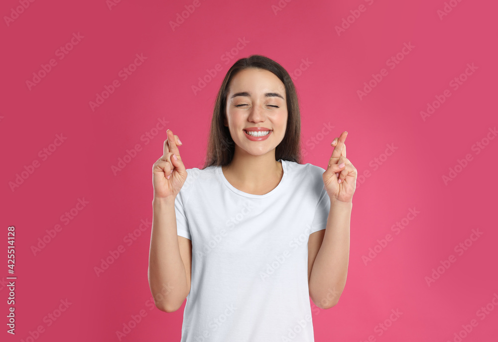 Sticker Woman with crossed fingers on pink background. Superstition concept