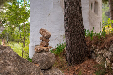 Stones stacked in the shape of a landmark, in a forest.