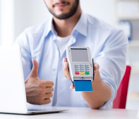 Man processing credit card transaction with POS terminal
