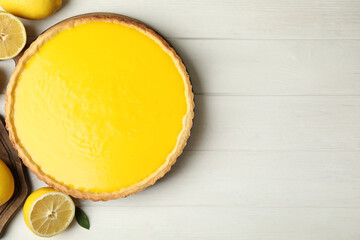 Delicious homemade lemon pie and fresh fruits on white wooden table, flat lay. Space for text