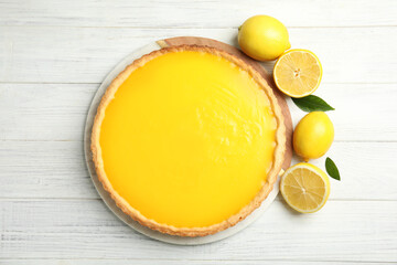 Delicious homemade lemon pie and fruits on white wooden table, flat lay