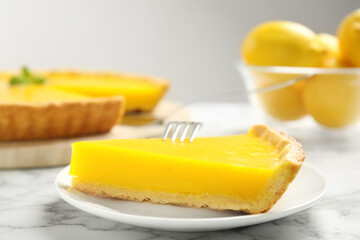 Slice of delicious homemade lemon pie on white marble table