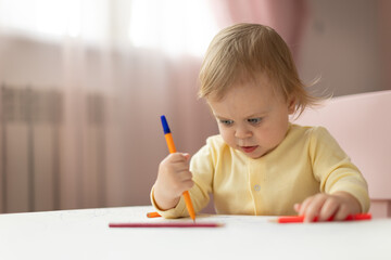 Baby draws at the table