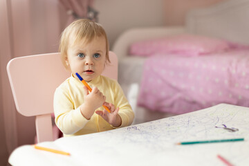 Baby draws at the table