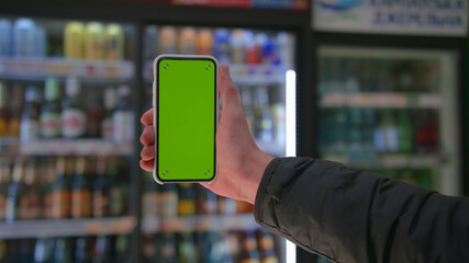 Man hand holding the smartphone on green screen chroma key background