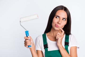 Photo of lady hold roller finger chin look empty space think wear green overall isolated white color background