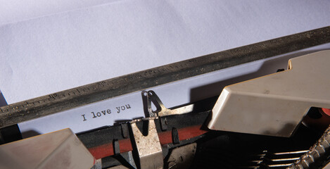 Typewriter, beautiful details of an old typewriter and a sheet written I love you, selective focus.