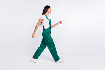 Profile photo of positive pretty lady step wear green overall sneakers isolated white color background