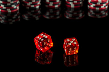 Poker dice with winning combination of eleven on black table and chips in the background