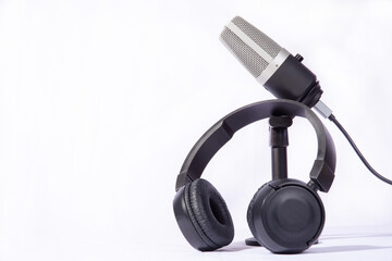 home work, professional condenser microphone and headphones on white background, high key portrait,...